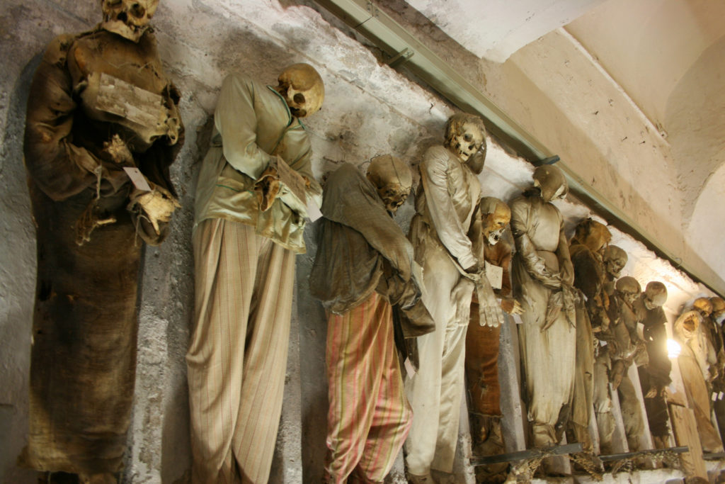 mummie vestite in fila contro il muro