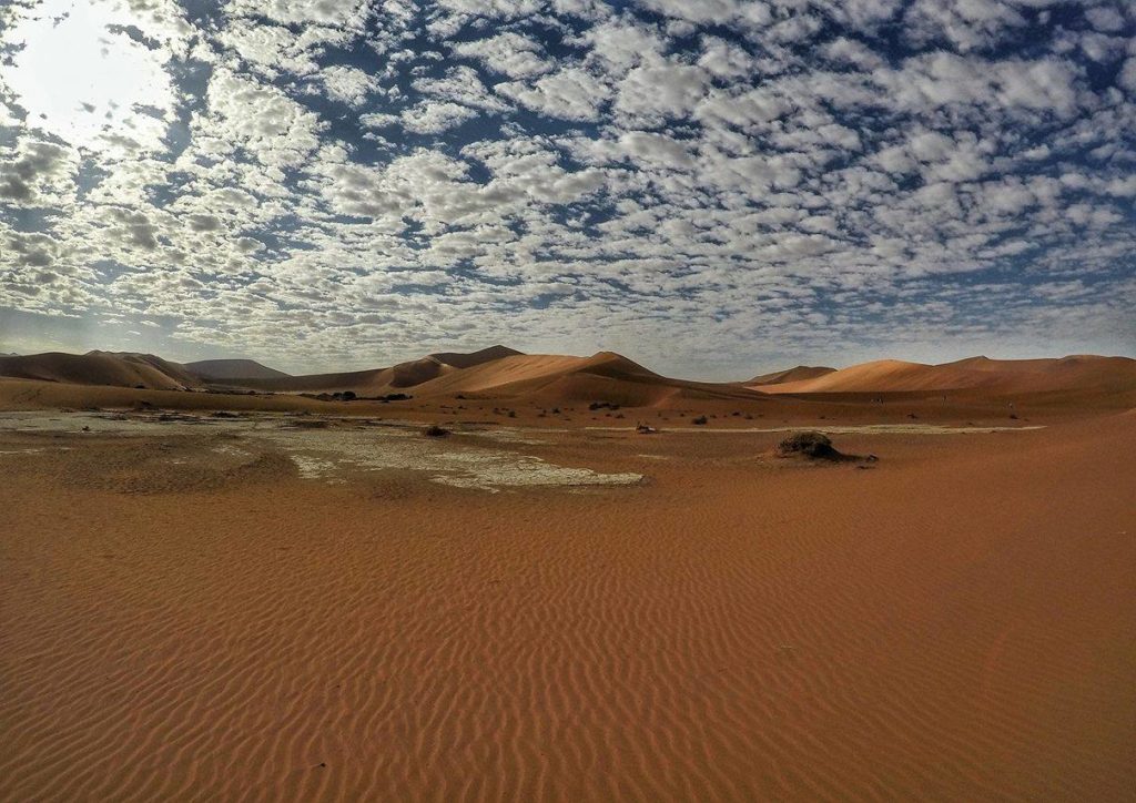 Dune di sabbia rossa con il cielo pieno di nuvole